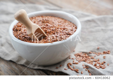 White bowl of whole flax seeds, linseeds on table White bowl of whole flax seeds, linseeds on table 60418062