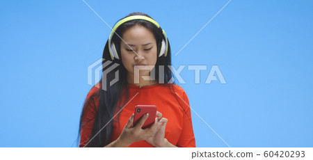 Young woman using smartphone as a mirror Young woman using smartphone as a mirror 60420293