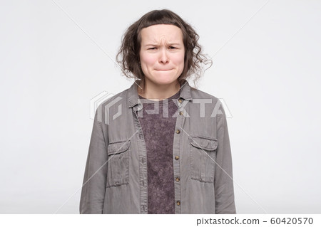 Young caucasian female student feeling guilt for mistake in term paper 60420570