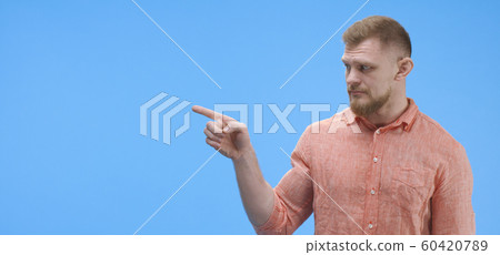 Young man pointing with finger Young man pointing with finger 60420789