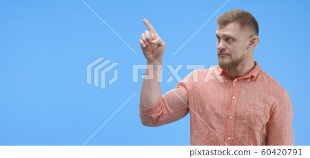 Young man pointing with finger Young man pointing with finger 60420791