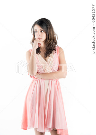Isolated young woman on a pink dress while on deep thought 60421577