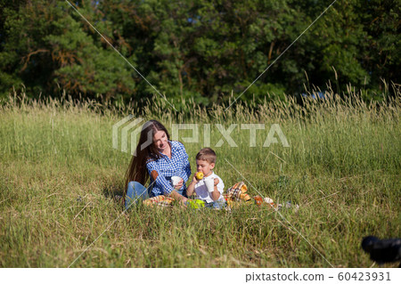 Beautiful mom with her son on a picnic rest in nature 60423931