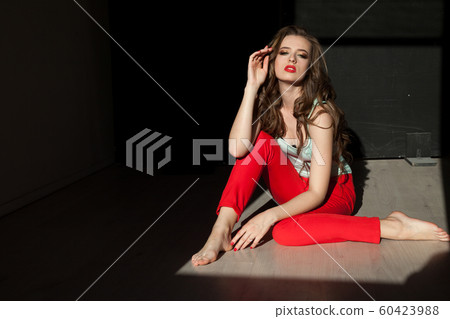 Beautiful fashionable woman with hair curls in red pants Beautiful fashionable woman with hair curls in red pants 60423988