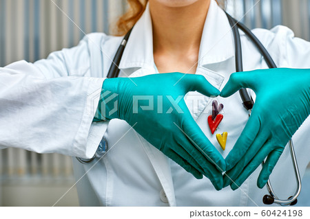 doctor shows simbols of heart through the hands folded in the shape of a heart with medical care concept, Medicine in hospital, cardiology. doctor shows simbols of heart through the hands folded in the shape of a heart with medical care concept, Medicine in hospital, cardiology. 60424198