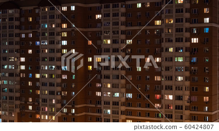 Facade view of living apartment building with glowing windows at night Facade view of living apartment building with glowing windows at night 60424807