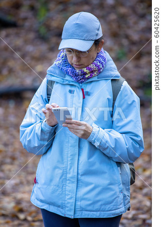 Pretty tourist in the forest looking at mobile 60425620