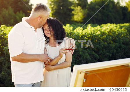 Beautiful adult couple drawing in a summer field 60430635
