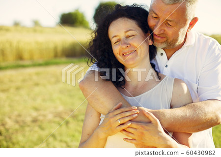 Beautiful adult couple spend time in a summer field Beautiful adult couple spend time in a summer field 60430982