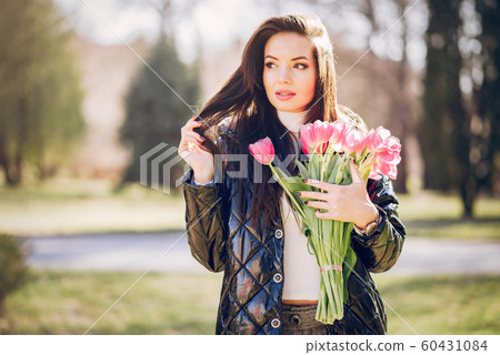 Elegant brunette in a summer park Elegant brunette in a summer park 60431084