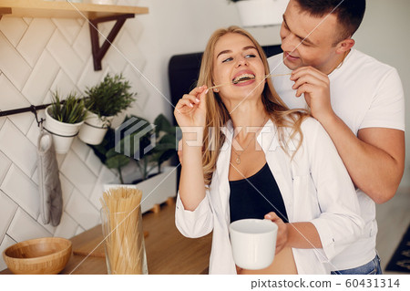 Beautiful couple spend time in a kitchen Beautiful couple spend time in a kitchen 60431314