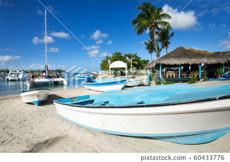 Caribbean beach with wooden boats and catamaran 60433776