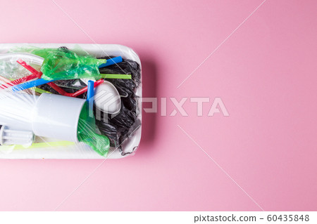 Set of plastic waste in a packed tray on a pink isolated background. The problem of ecology and environmental pollution. Set of plastic waste in a packed tray on a pink isolated background. The problem of ecology and environmental pollution. 60435848
