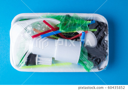 Set of plastic waste in a packed tray on a blue isolated background. The problem of ecology and environmental pollution. Set of plastic waste in a packed tray on a blue isolated background. The problem of ecology and environmental pollution. 60435852