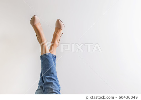Female legs dressed in jeans and high heel shoes 60436049