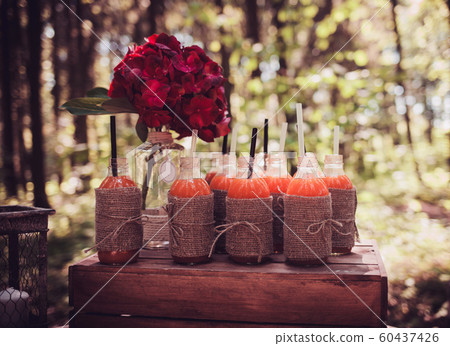 bottles of juice and red flowers bottles of juice and red flowers 60437426