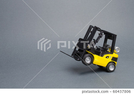 Yellow forklift truck rides on the rear wheels on gray background. Warehouse equipment, vehicle. Logistics and transport infrastructure, industry and agriculture. Unloading, transportation, sorting 60437806