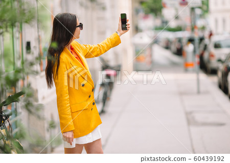 Woman talk by her smartphone in city. Young attractive tourist outdoors in italian city Woman talk by her smartphone in city. Young attractive tourist outdoors in italian city 60439192