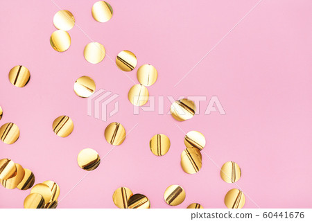 Close up of gold metallic confetti on pastel pink background. Close up of gold metallic confetti on pastel pink background. 60441676