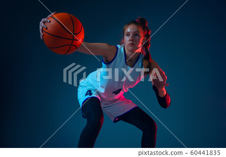 Young caucasian female basketball player on blue studio background in neon light Young caucasian female basketball player on blue studio background in neon light 60441835