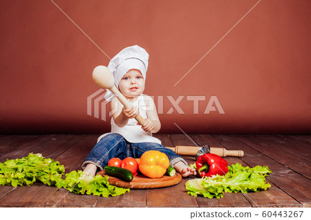 the boy chef with a wooden spoon, carrots, peppers, tomatoes, lettuce, cucumber 60443267