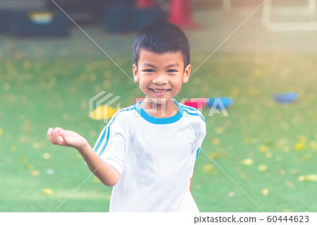 Asian boy is running and smiling in sport field 60444623