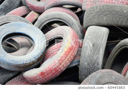 A picture of many old used tires left on a waste A picture of many old used tires left on a waste 60445863