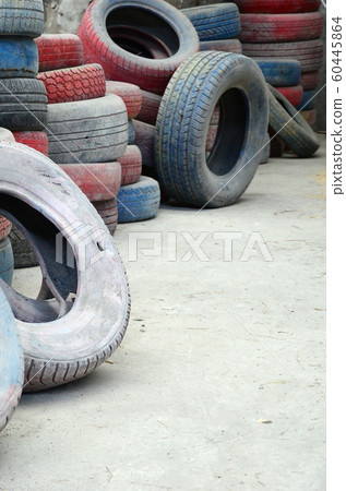 A picture of many old used tires left on a waste 60445864