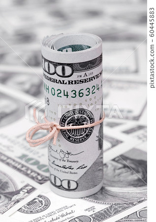 US dollars rolled up and tightened with band lies 60445883