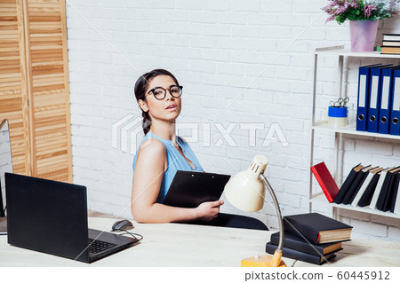 business girl sits at a computer in the Office paper folders business girl sits at a computer in the Office paper folders 60445912