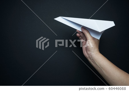 Hand holding paper airplane on black background , travel plan concept 60446088