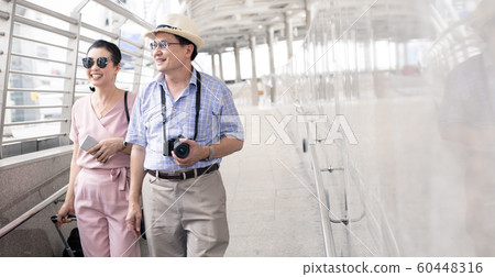 Senior Asian couple with a woman dragging a 60448316
