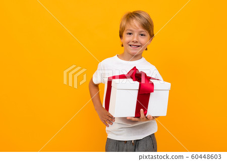 smiling boy with festive box on a yellow background 60448603