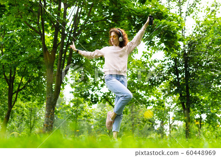 Pretty young caucasian woman dances in the park Pretty young caucasian woman dances in the park 60448969