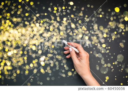 Woman hand with golden bokeh lights on background 60450036