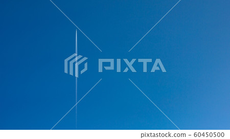 Airplane and inversion trail against a clear blue sky. 60450500