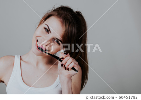pretty girl in the bathroom brushing his teeth smile 60451782