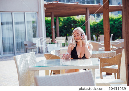 girl at the beach restaurant talking on the phone girl at the beach restaurant talking on the phone 60451989