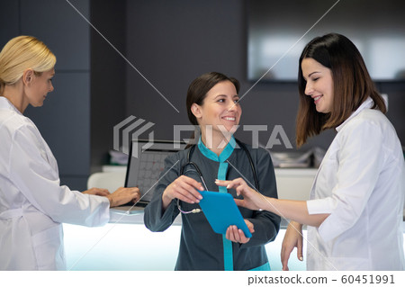 Beautiful female doctors watching video on tablet Beautiful female doctors watching video on tablet 60451991