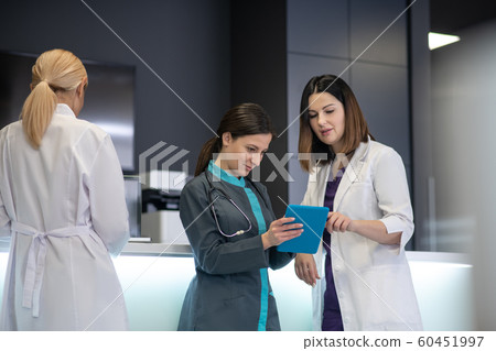 Young dark-haired female doctor holding a tablet 60451997
