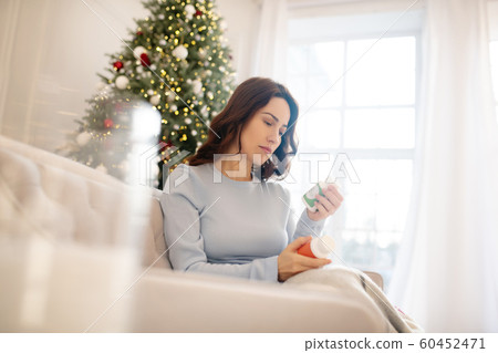 Dark-haired young woman holding pills in her hands 60452471