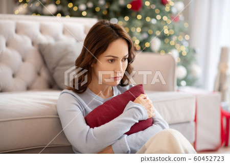 Pretty young woman hugging pillow and looking upset 60452723