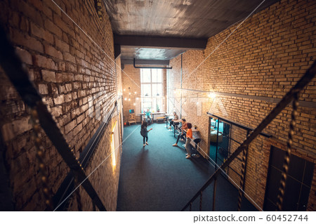 Freelancers enjoying their break in spacious work hub with brick walls Freelancers enjoying their break in spacious work hub with brick walls 60452744