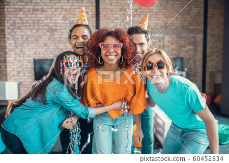 Best loving friends smiling and hugging their birthday girl Best loving friends smiling and hugging their birthday girl 60452834