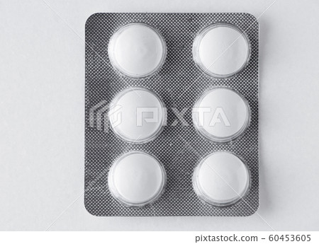 A plate of white pills on a marble background 60453605