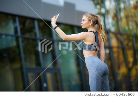 Sportswoman taking a break after workout and using phone outdoors 60453606