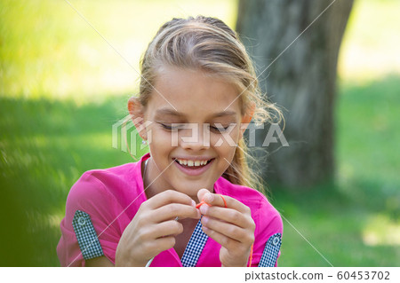 Portrait of a girl who knits on a knitting needles Portrait of a girl who knits on a knitting needles 60453702