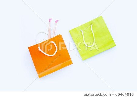 Woman doll legs with paper shopping bags on white Woman doll legs with paper shopping bags on white 60464016