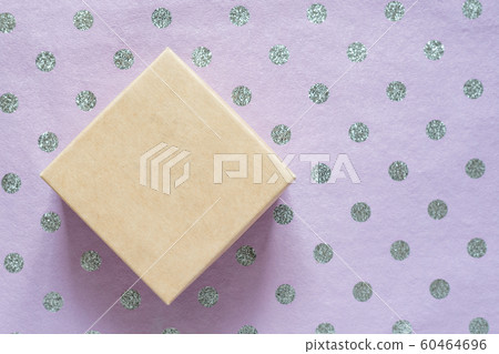 Cardboard box and lilac polka dot wrapping paper. 60464696