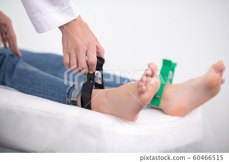 Doctor in white robe getting the patient ready for electrocardiogram Doctor in white robe getting the patient ready for electrocardiogram 60466515
